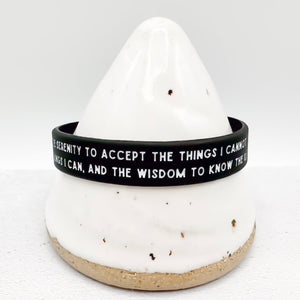 A black silicone bracelet with white printed text