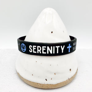 A black silicone serenity bracelet with white and blue text and symbols