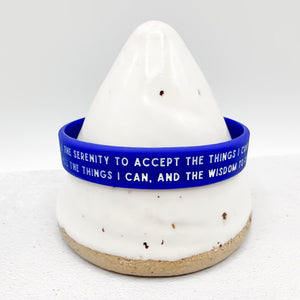 A blue silicone wristband with white text 
