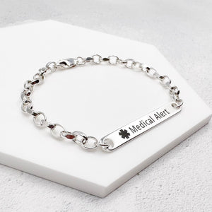 Silver medical alert bracelet on a white surface