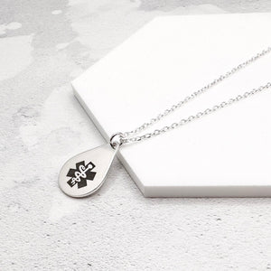 sterling silver medical alert necklace with star of life symbol on a teardrop-shaped pendant on a marble surface