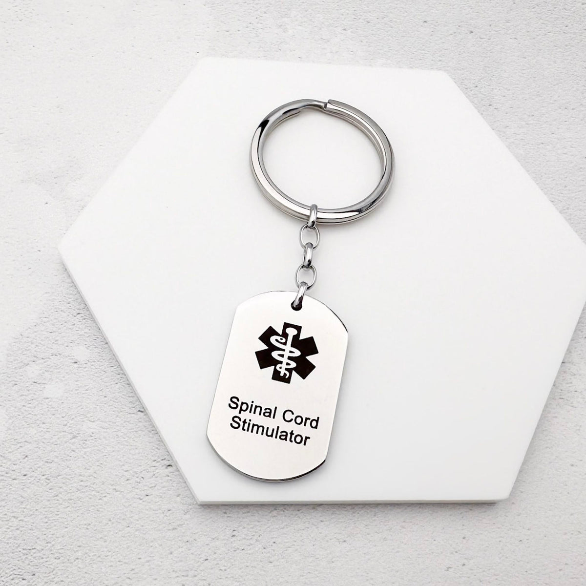 stainless steel keychain with star of life medical symbol and 'Spinal Cord Stimulator' text
