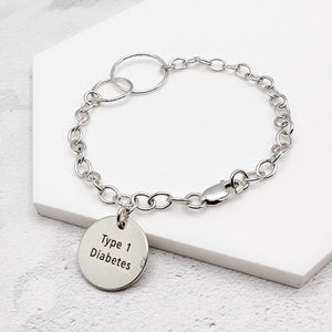 Silver bracelet with a 'Type 1 Diabetes' charm on a white background