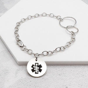 silver chain bracelet with a round tag featuring the star of life medical symbol and interlocking rings