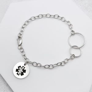 sterling silver chain bracelet with a round tag featuring the star of life medical symbol on a light background