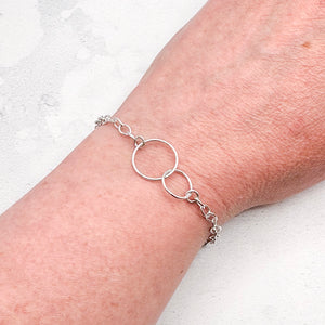 silver bracelet on a wrist against a light background