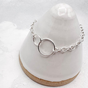 sterling silver chain bracelet with a interlocking rings on a white surface