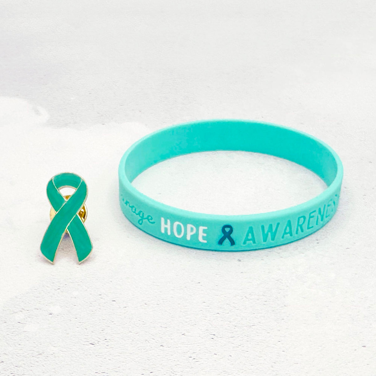 teal silicone wristband engraved with ‘Hope & Awareness’ besides matching teal enamel ribbon pin