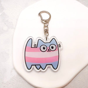 Transgender cat keychain featuring the trans flag colours of blue, pink, and white