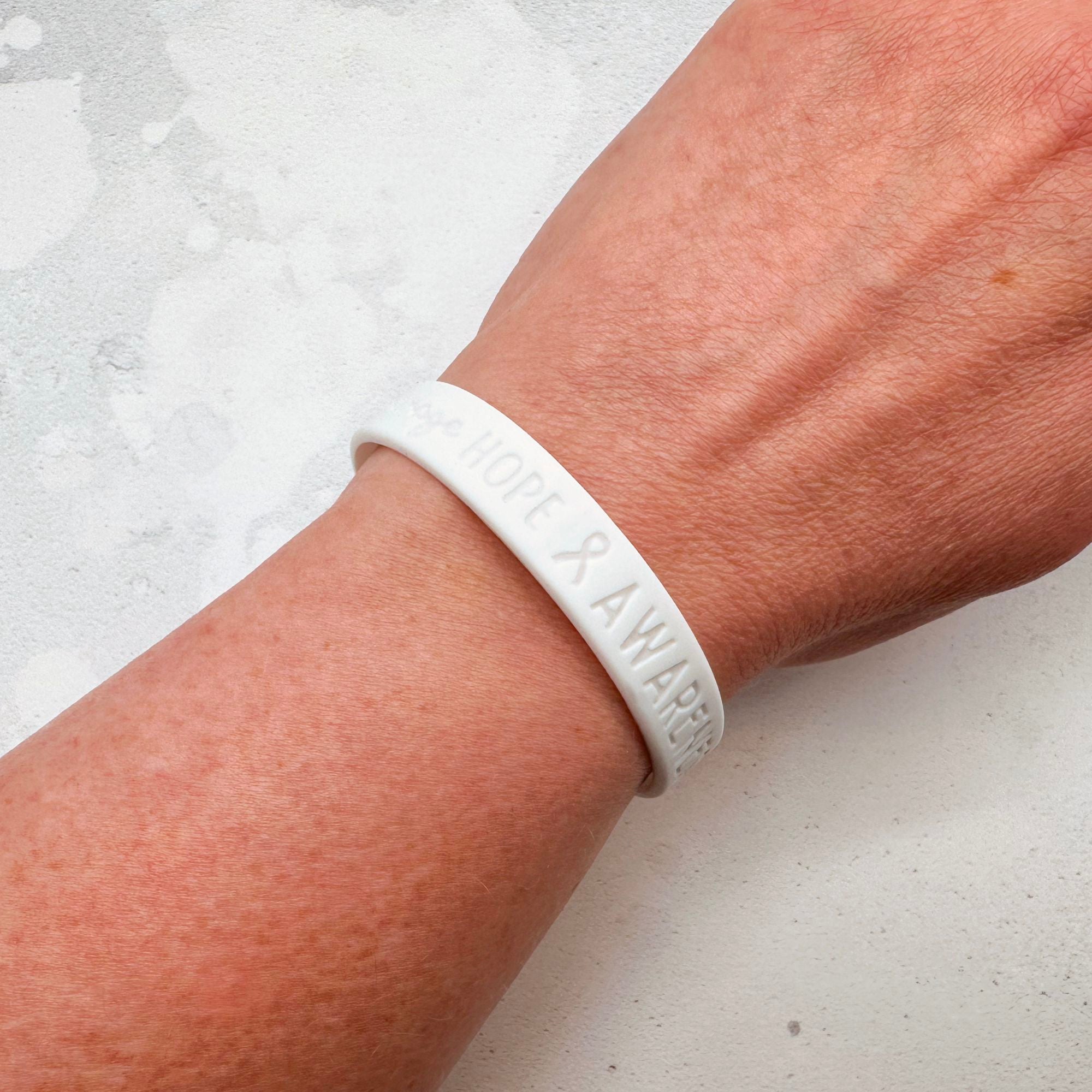 white silicone wristband engraved with ‘Hope & Awareness’ worn on person's wrist