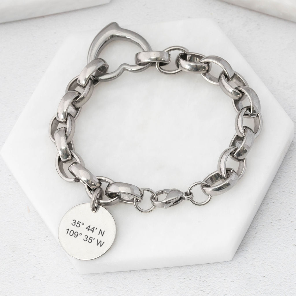 Chunky-style chain bracelet made from stainless steel with heart connector link and a round tag depicting coordinates