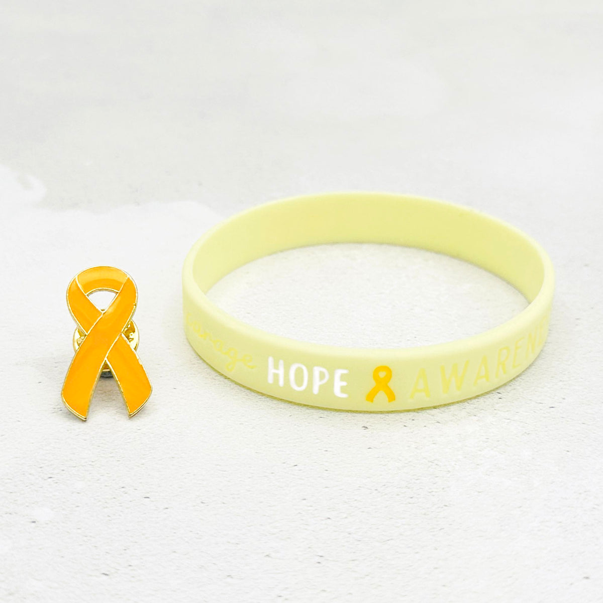 yellow silicone wristband engraved with ‘Hope & Awareness’ besides matching yellow enamel ribbon pin